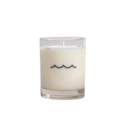 Candle in a glass jar with wavy design on a light gray background